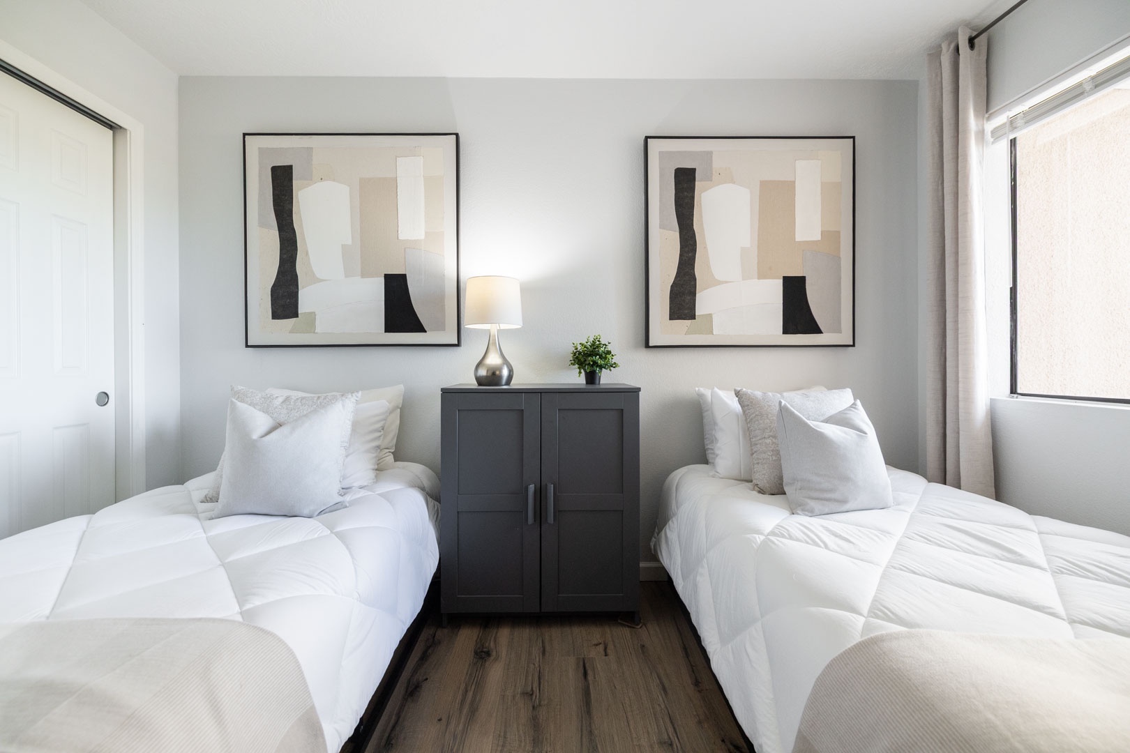 Twin beds with crisp linens await your perfect night's sleep in this bright, modern bedroom.