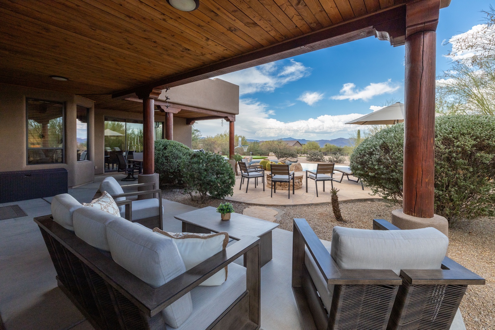 Covered outdoor patio overlooking the pool and distant mountains