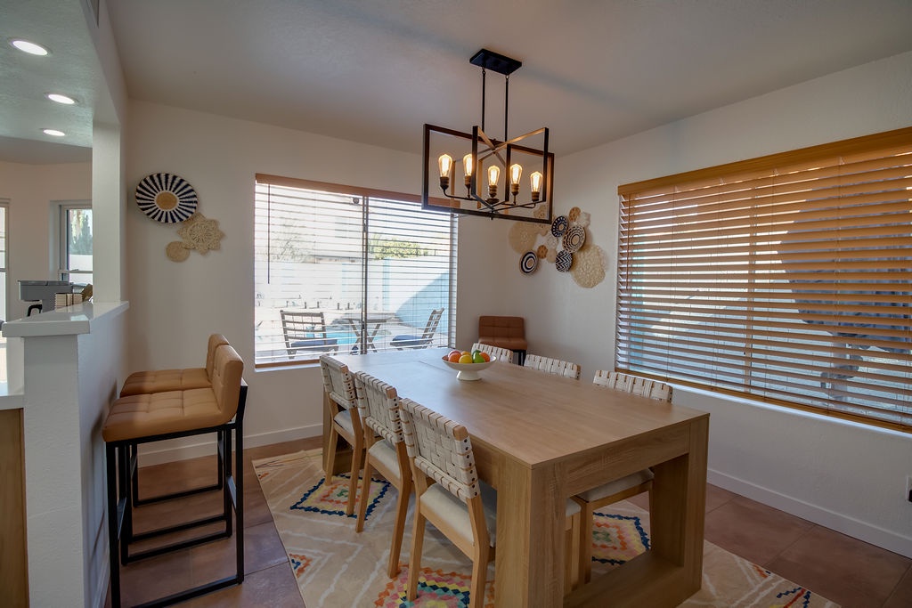 Gather around your stylish dining table where warm wood tones and thoughtful lighting create the perfect setting for memorable meals together.