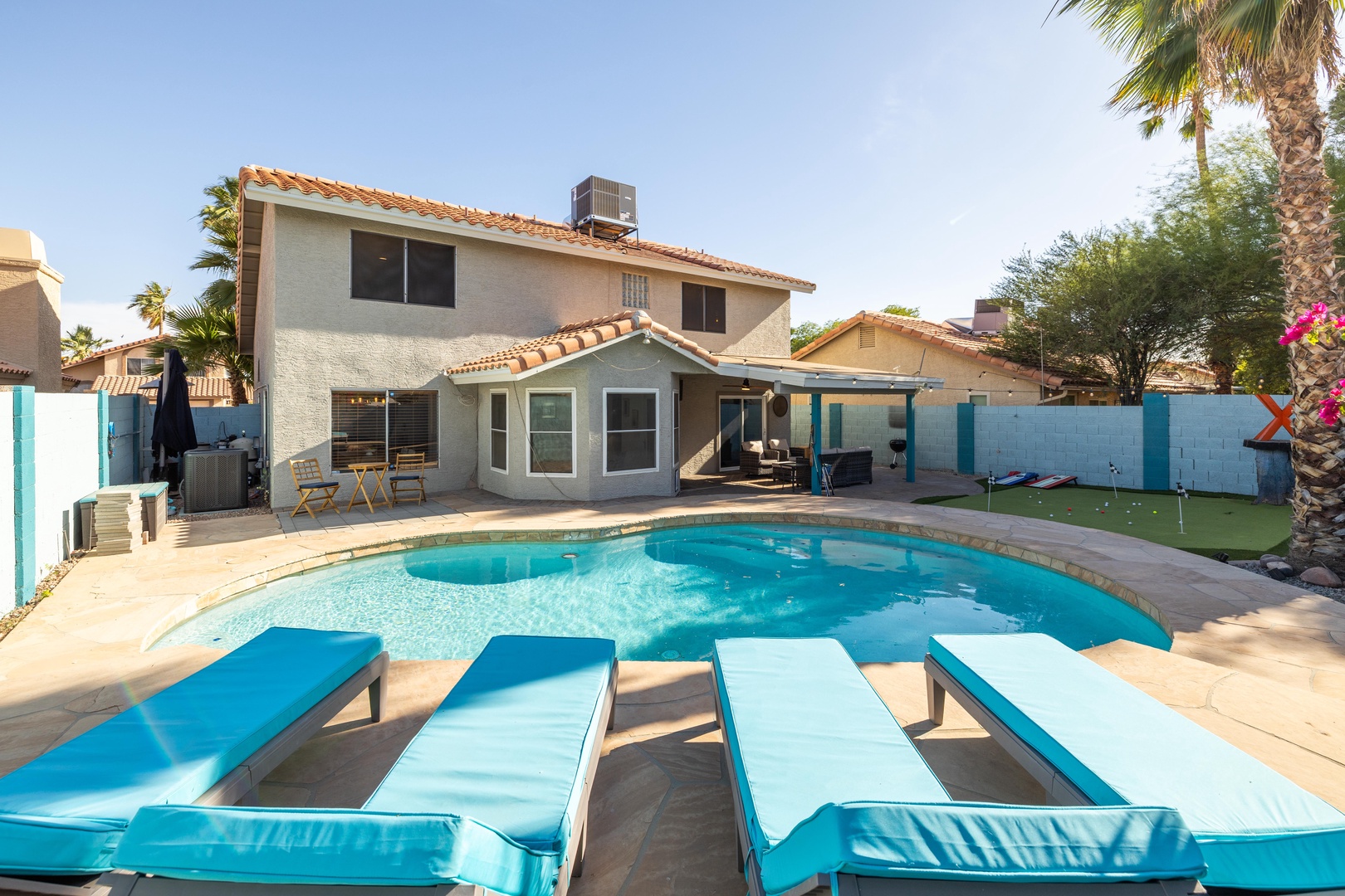 Spacious backyard with sparkling pool and sun loungers