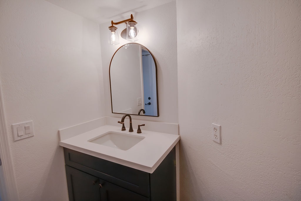 Freshen up at your stylish vanity with warm lighting and elegant fixtures creating the perfect morning routine space.