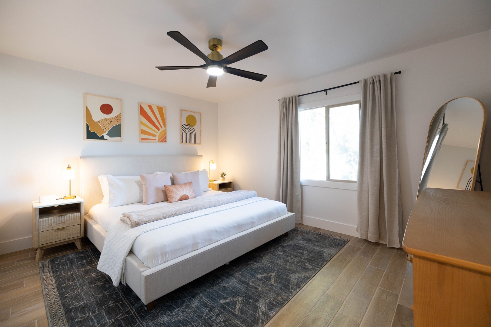 Drift off in your serene 2nd bedroom with modern art, natural light, and gentle ceiling fan.