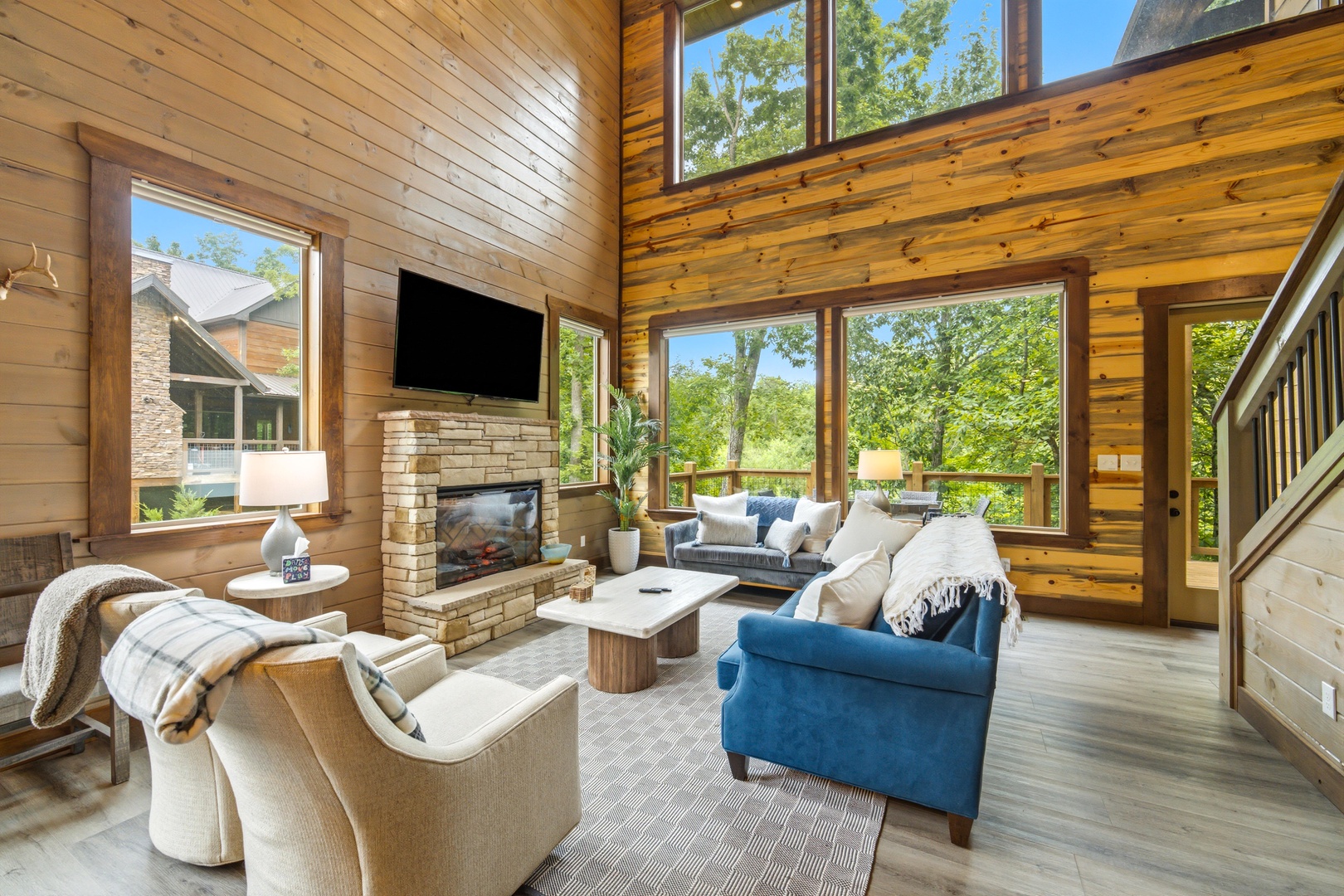 Sink into plush seating surrounded by soaring wood-paneled walls and floor-to-ceiling windows that frame lush forest views, creating your perfect retreat for relaxation.