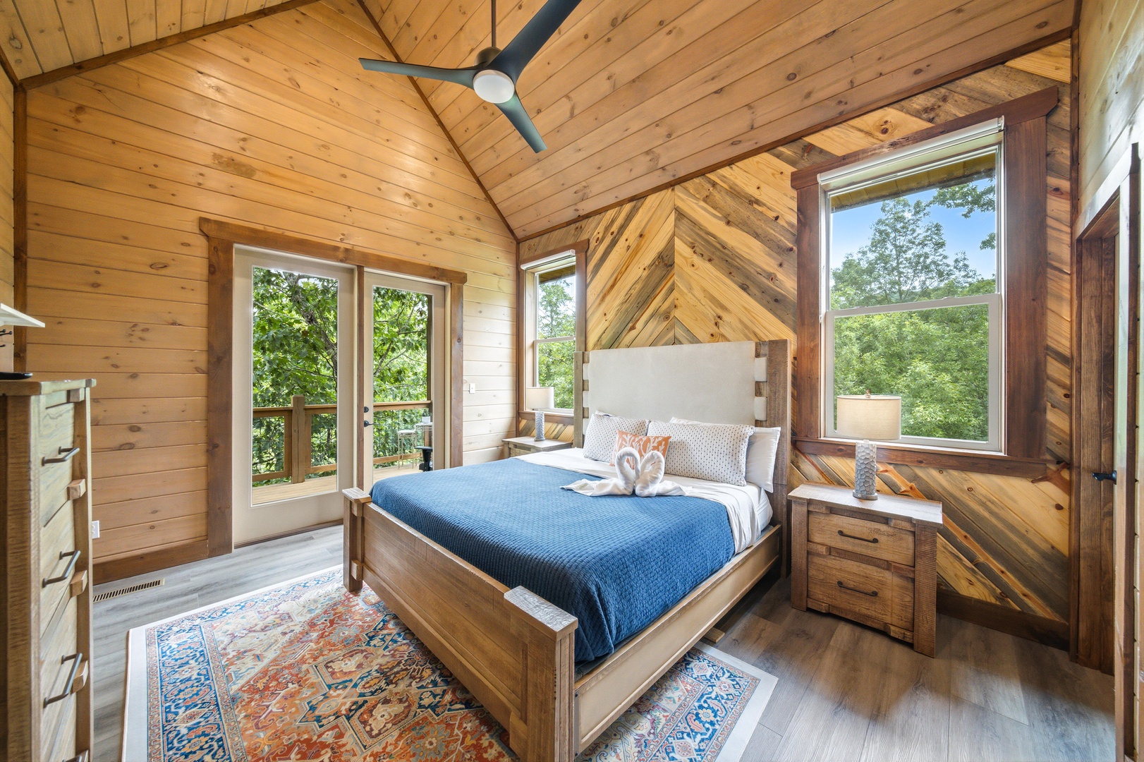 Retreat to your bedroom featuring vaulted ceilings, handcrafted wood accents, and a peaceful treetop view. The plush bed and soft linens invite restful nights in this warm, nature-wrapped sanctuary.