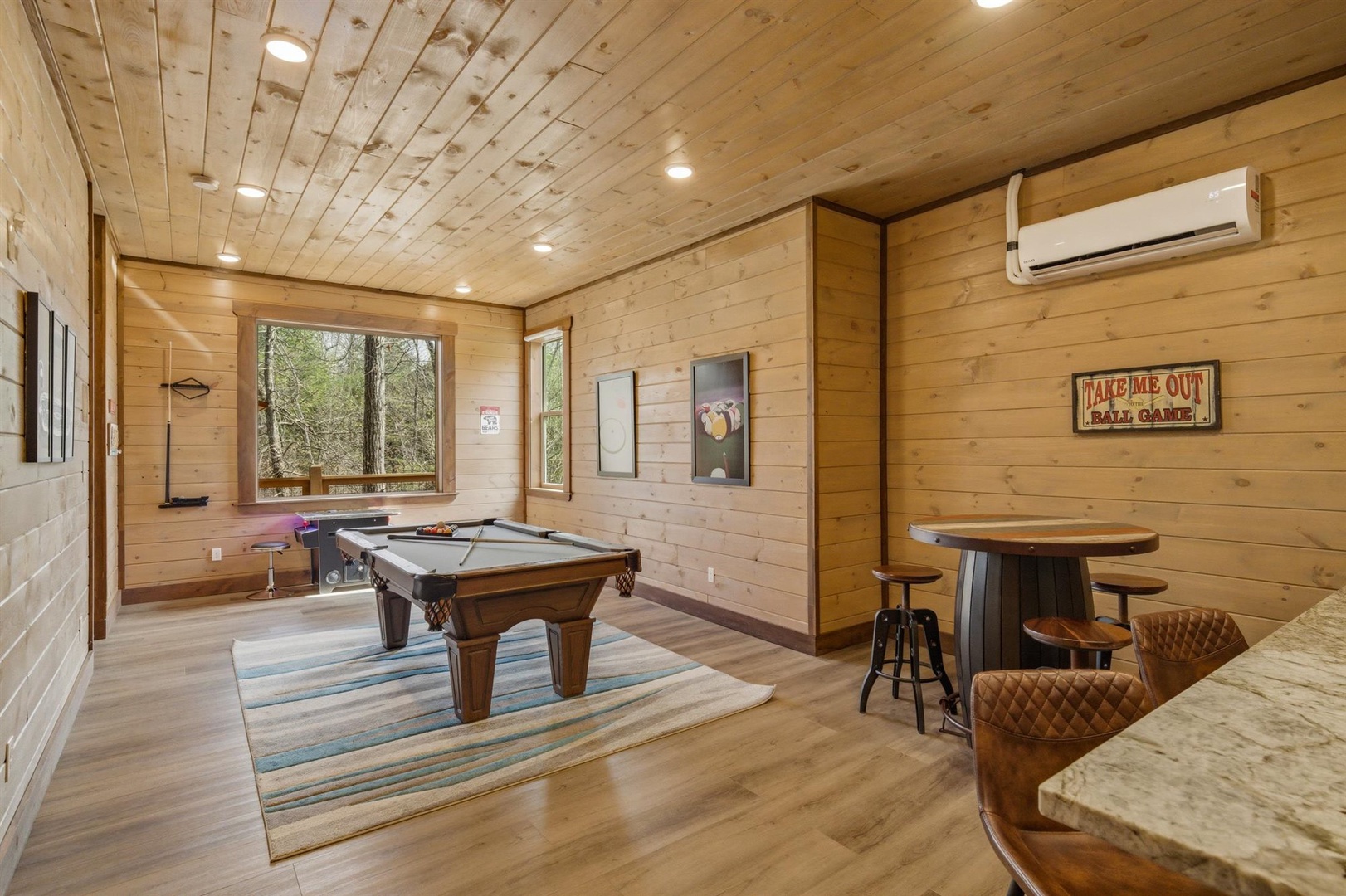 Challenge friends to pool games in your private game room, featuring rich wood accents and forest views.