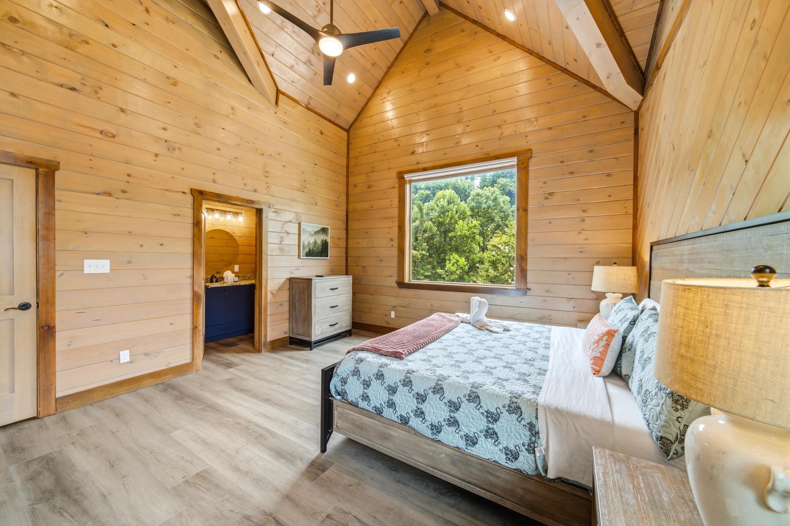 Drift off under soaring wood ceilings and natural light streaming in from your forest-framed window, with plush bedding and rustic warmth waiting to wrap around you.