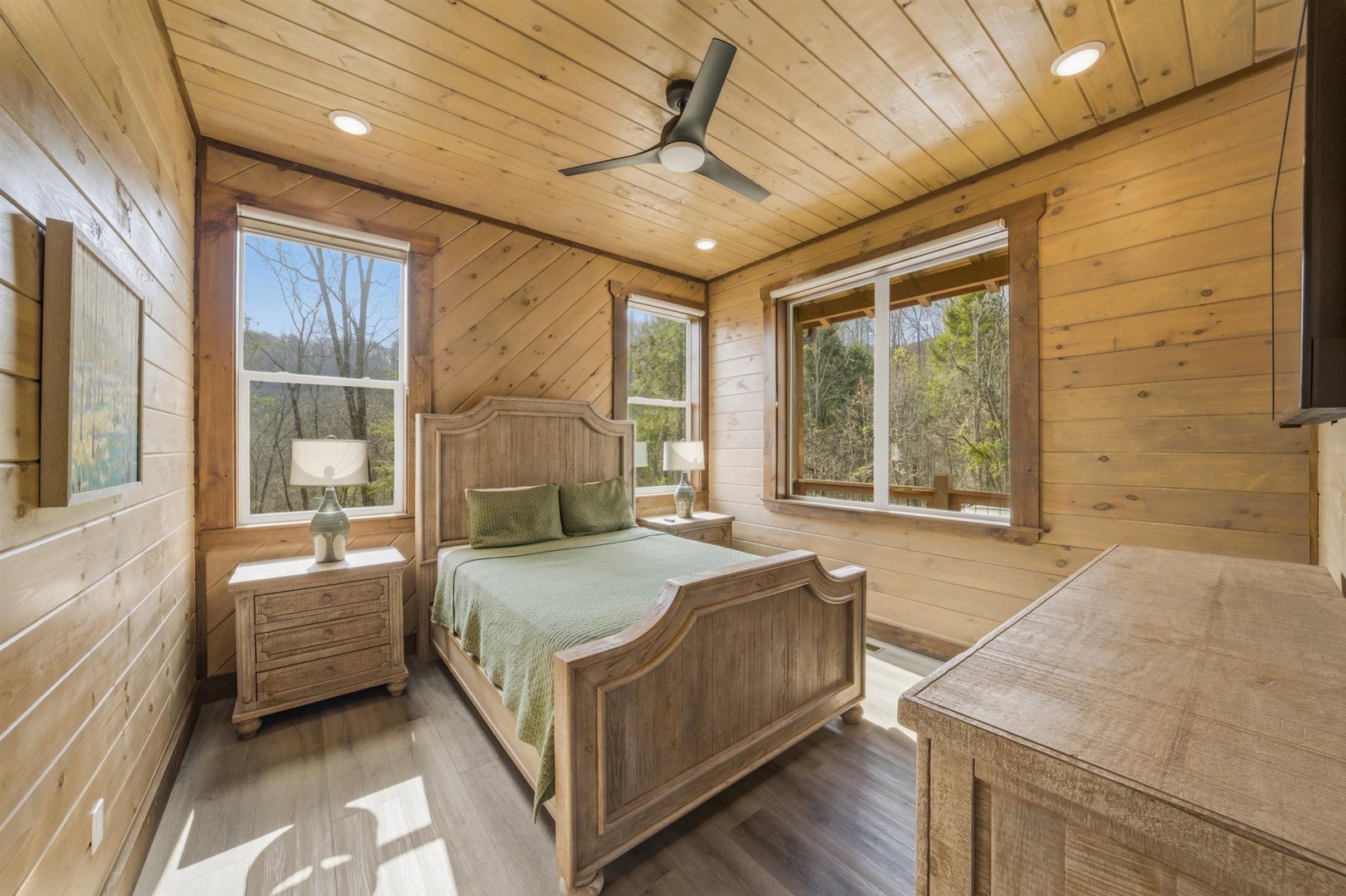 Wake up in your rustic cedar bedroom where natural light streams through windows, revealing peaceful forest views that make every morning magical.