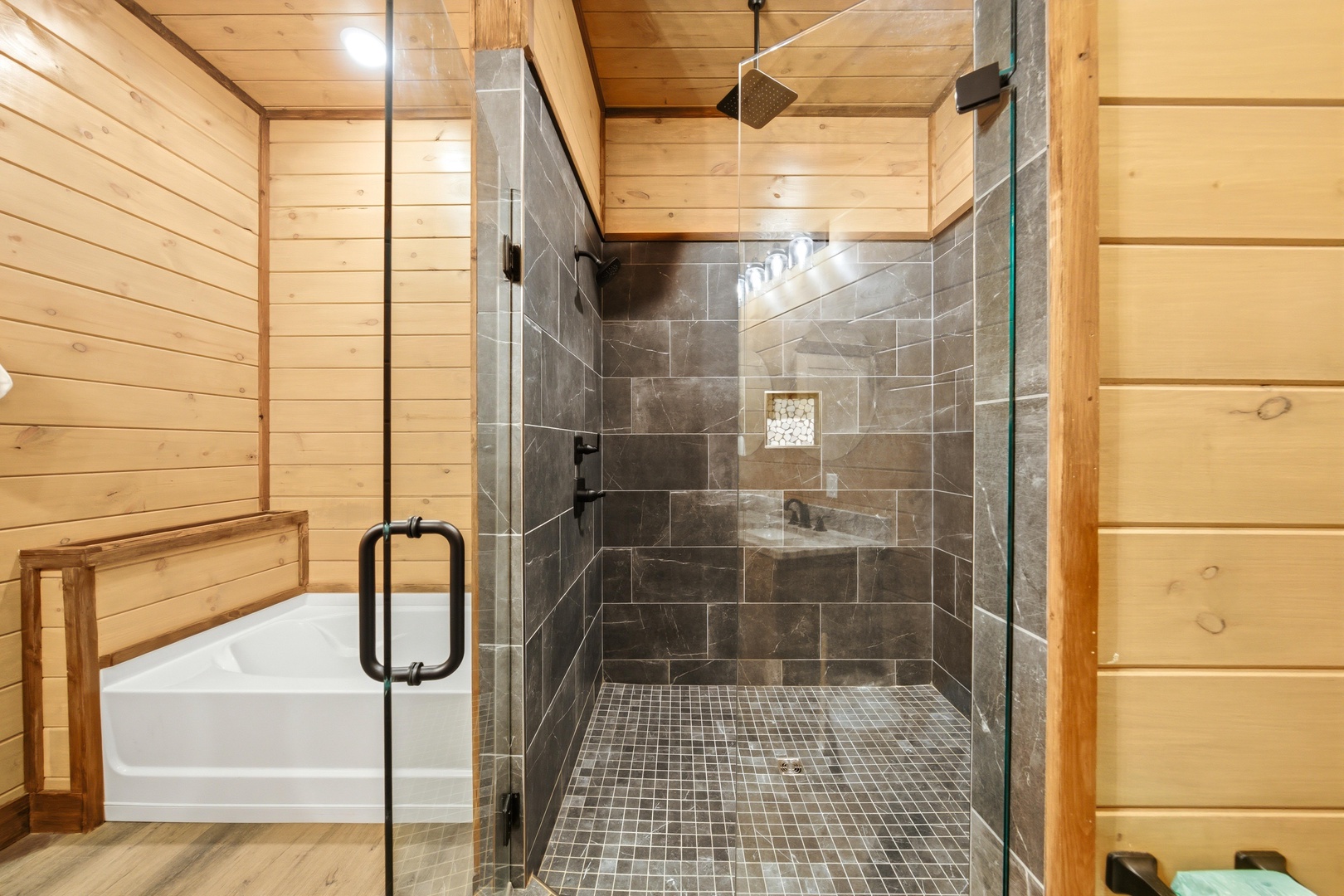 Step into your private spa-like retreat with a spacious walk-in shower featuring natural stone tiles and a rainfall showerhead, complemented by a soaking tub for ultimate relaxation.