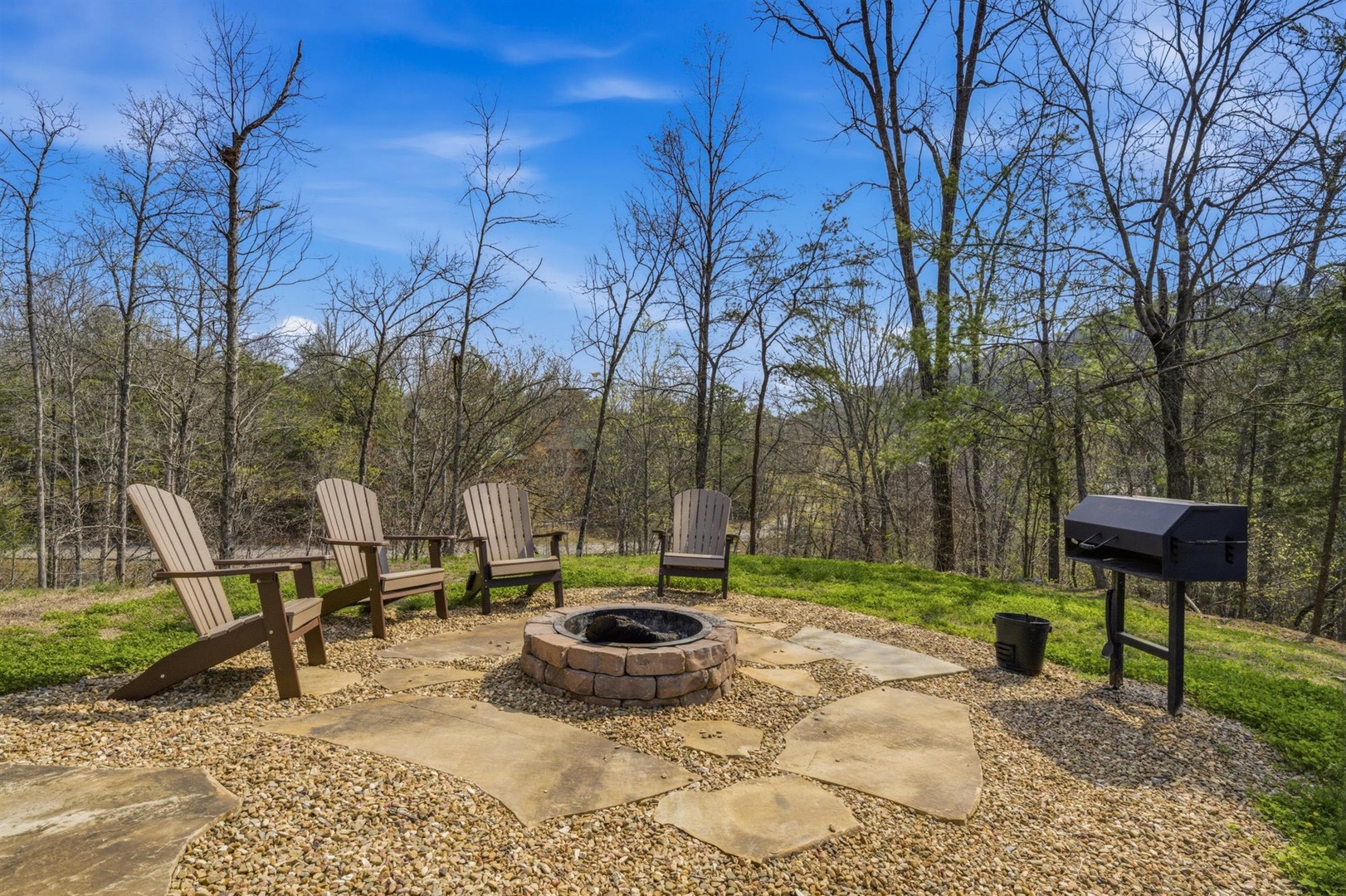 Gather around your private fire pit with comfortable Adirondack chairs, perfect for evening s'mores and stargazing in this peaceful woodland setting.