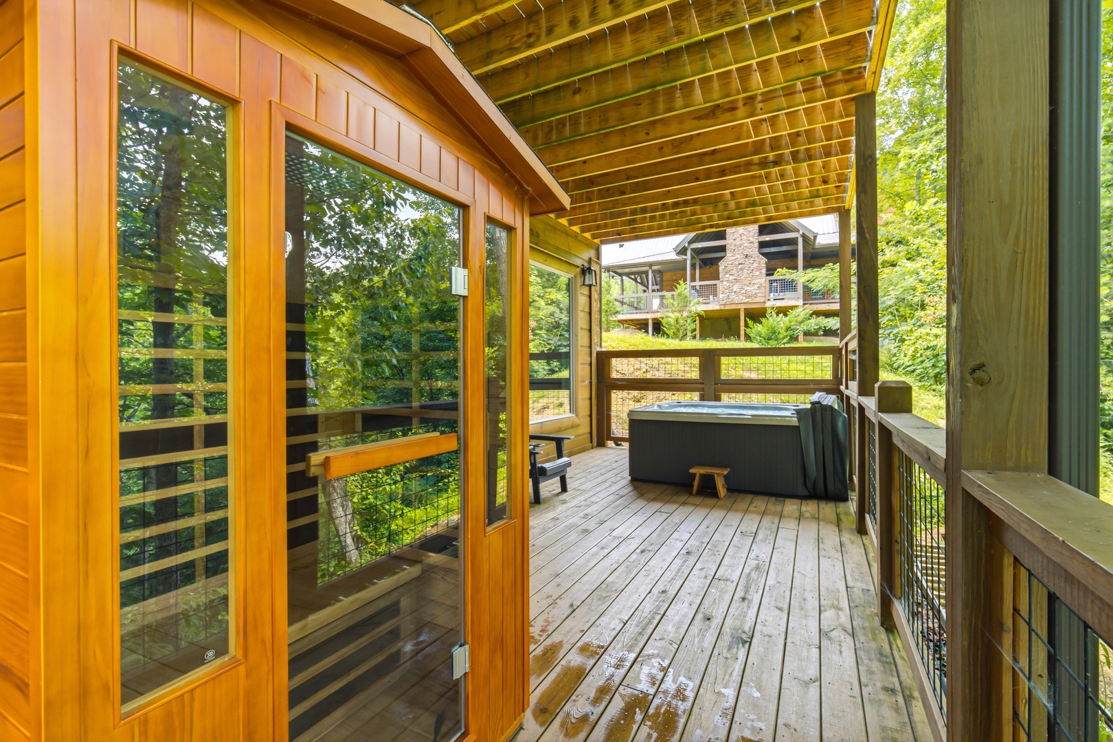 Step outside to your covered private deck with a hot tub and serene forest views—perfect for unwinding under the trees after a day of adventure.