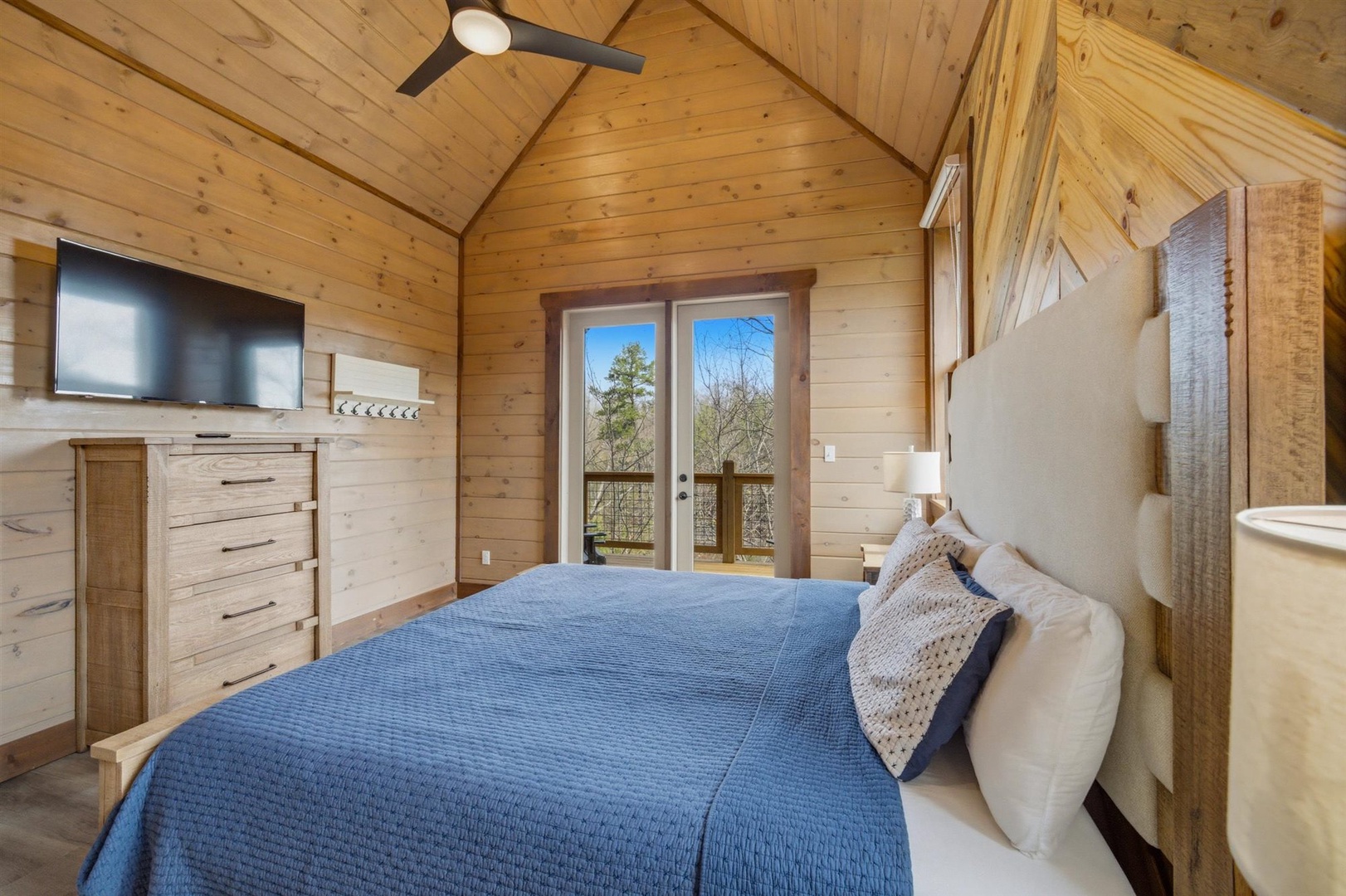 Drift off peacefully in your rustic-chic bedroom, where natural wood walls and vaulted ceilings create the perfect mountain cabin ambiance.