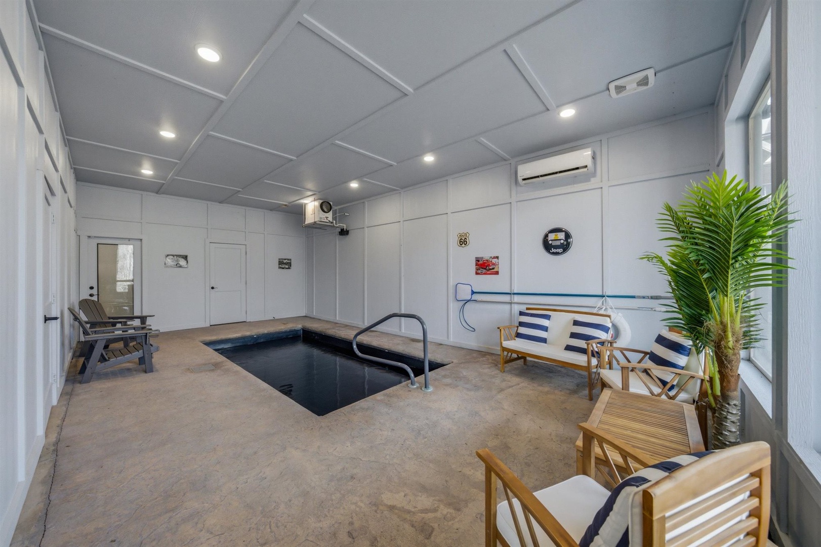 Unwind in your private indoor pool area with comfortable seating, tropical plants, and fitness equipment for a perfect wellness retreat.