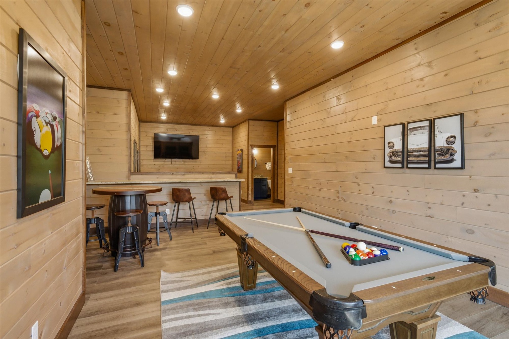 Unwind in your private game room with pool table, bar seating, and cozy wood-paneled warmth perfect for evening entertainment.