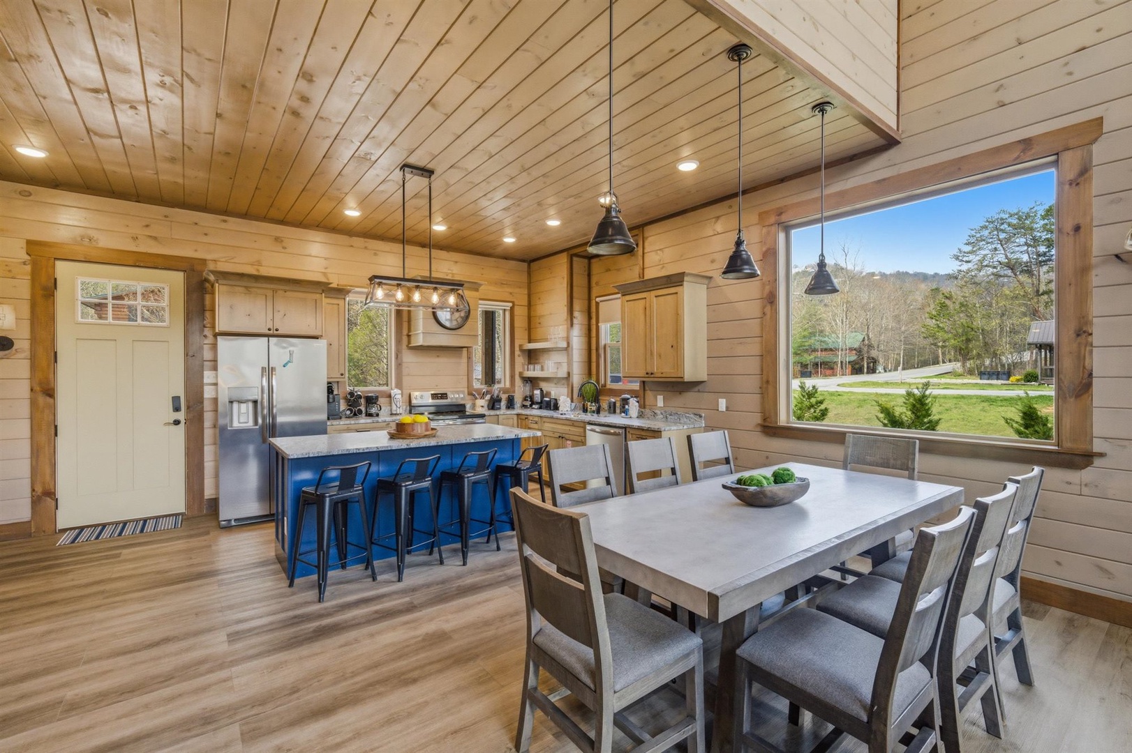 Cook and dine together in your spacious open kitchen featuring warm wood, modern appliances, and peaceful mountain views.