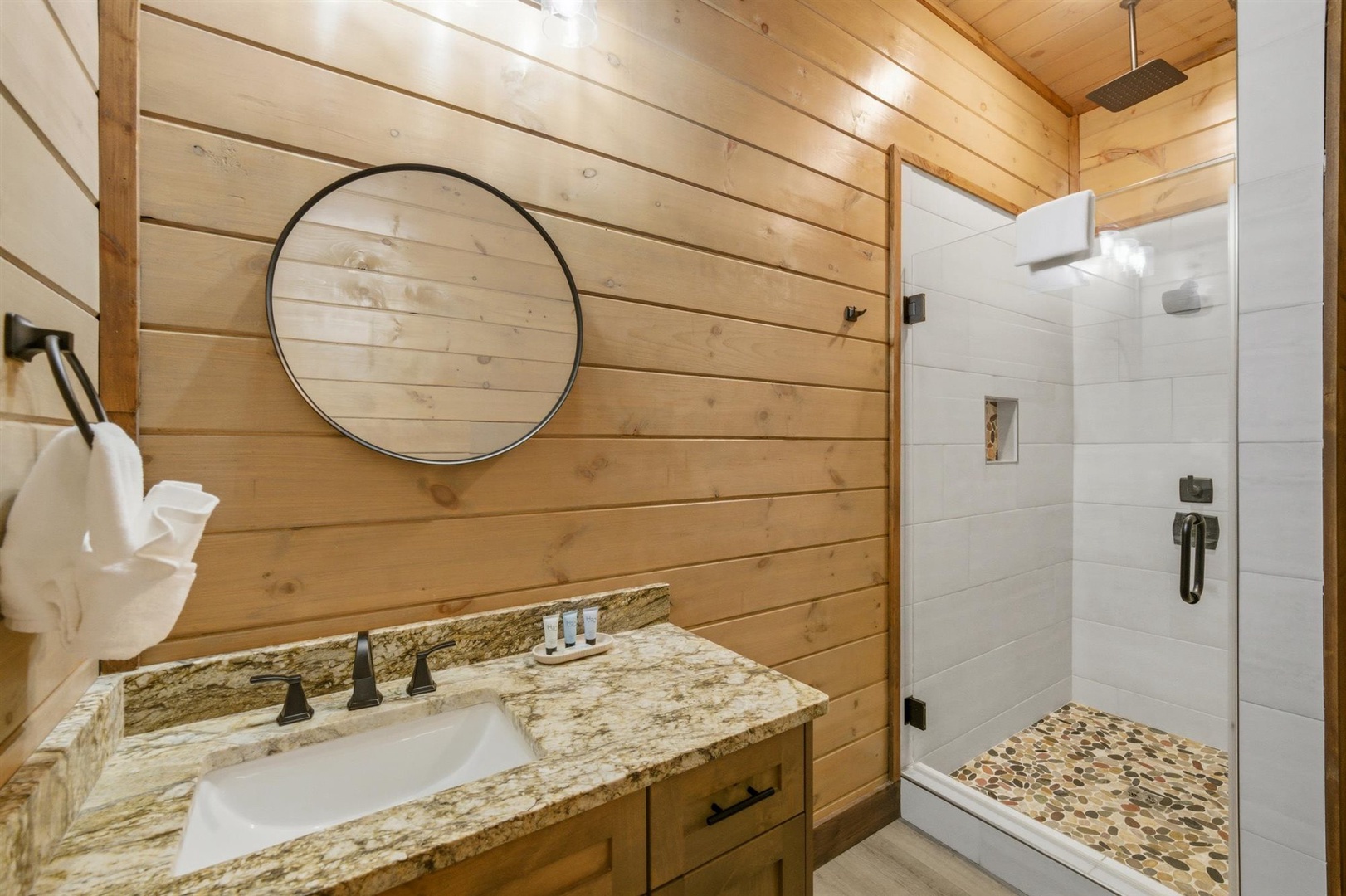 Step into your rustic-chic bathroom where warm wood meets elegant granite, creating the perfect retreat after your mountain adventures.
