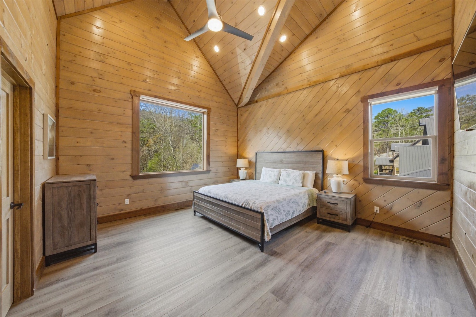 Rest peacefully in your cozy wood-paneled retreat with soaring vaulted ceilings and windows framing nature views.