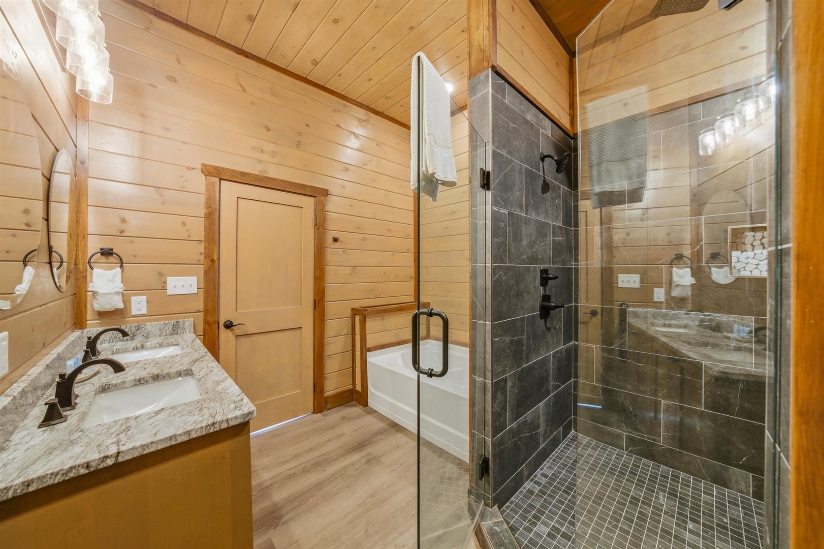 Unwind in your spa-like bathroom with rustic wood charm, featuring a luxurious walk-in shower and elegant granite vanity.