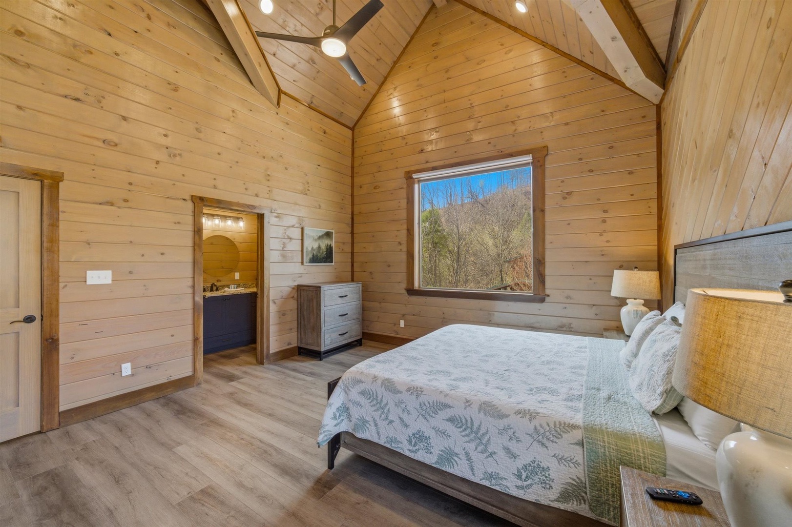 Wake up in your cozy timber bedroom with stunning views of autumn trees through your private window.