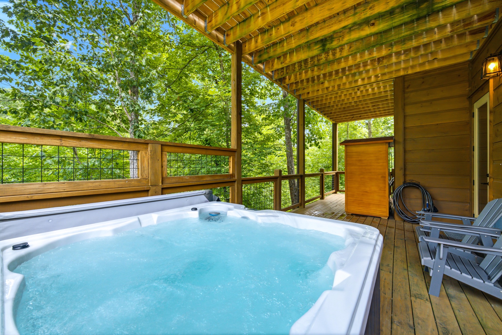 Soak in your private hot tub surrounded by lush forest views—pure relaxation awaits on this peaceful covered deck.