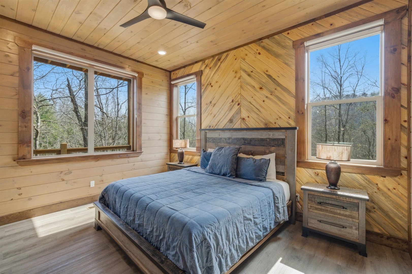 Drift off to sleep surrounded by warm wood and peaceful forest views in your private bedroom retreat.