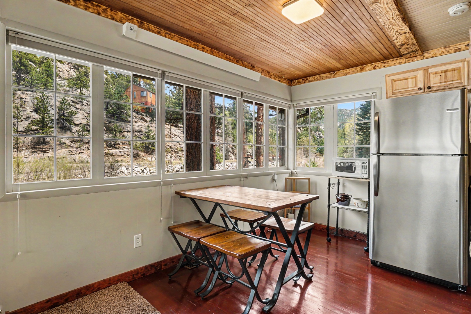 Enjoy meals under charming wood ceilings while natural light pours through expansive windows framing river outside. Your fully-equipped kitchen awaits culinary adventures.
