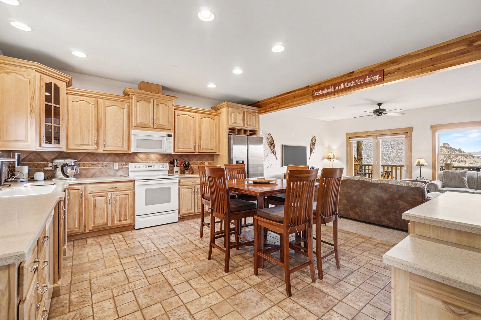 Cook together in this warm, open kitchen where rich wood cabinets meet modern appliances, flowing into your cozy living space.