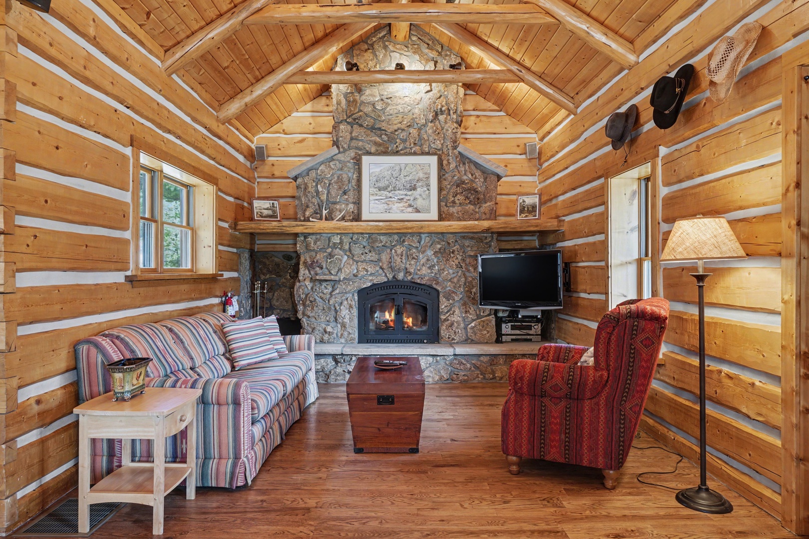 Curl up by the crackling stone fireplace in this cozy log cabin retreat, where rustic charm meets comfort.