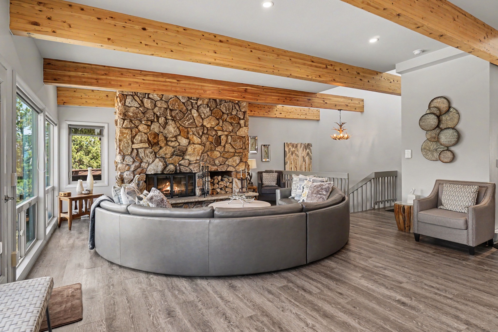 Gather around the stone fireplace in your stunning great room with soaring wood beams and expansive mountain views.