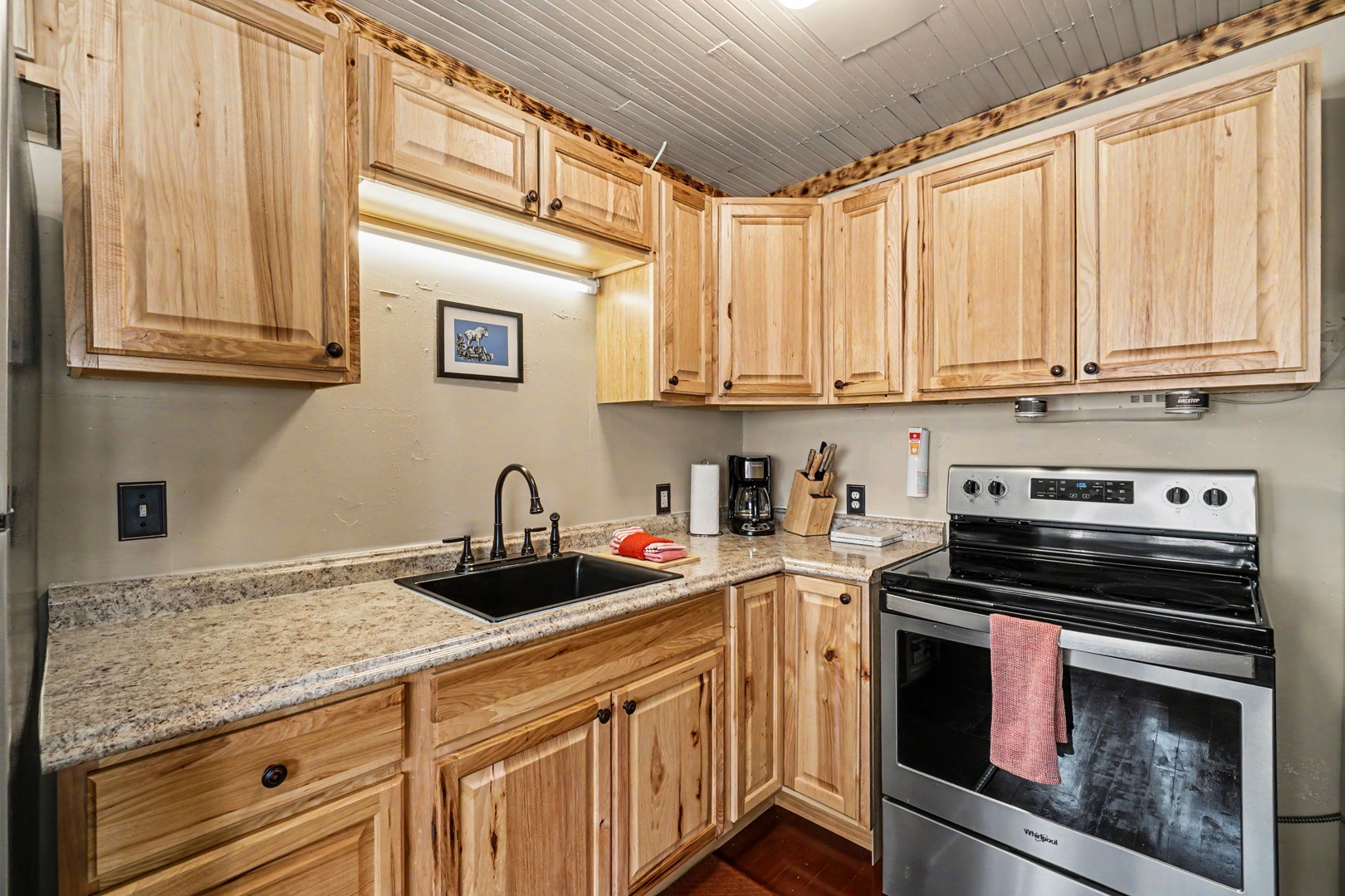 Your fully-equipped kitchen features warm wood cabinetry and everything needed to prepare meals during your stay.