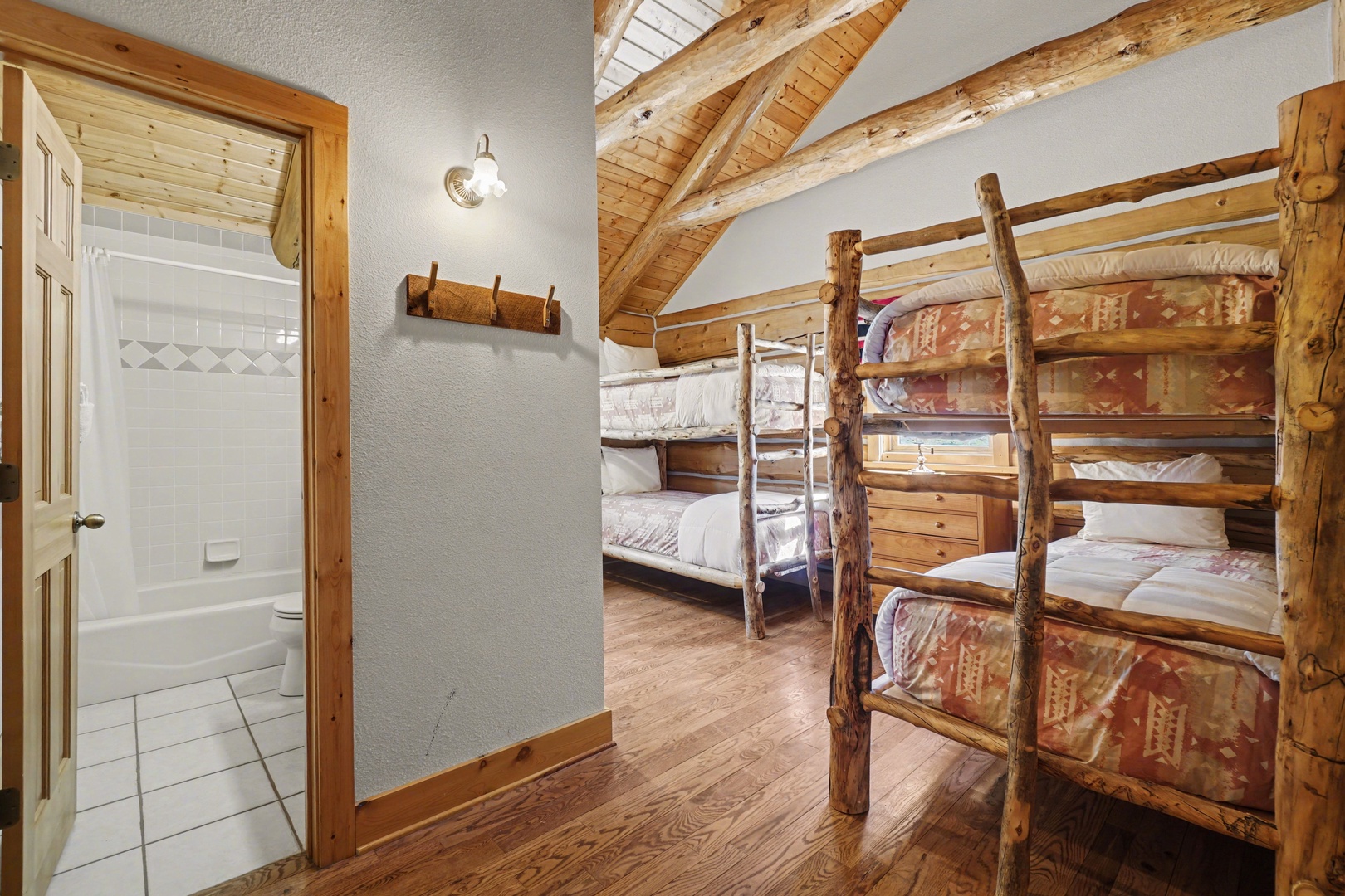 Cozy rustic bedroom with handcrafted log bunk beds and private ensuite bathroom for your mountain getaway comfort.