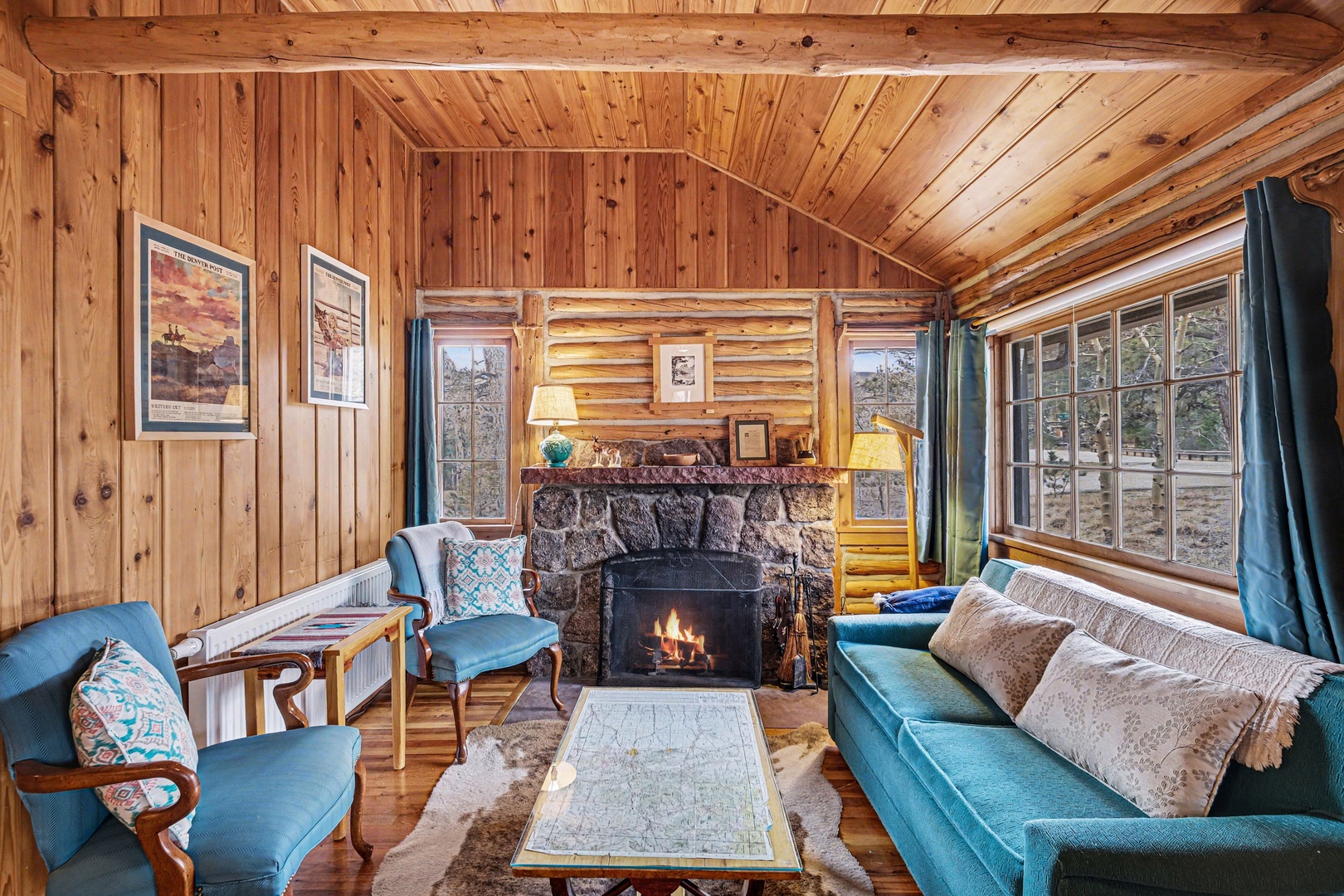 Enjoy the cozy living room with old timey log walls and crackling fireplace.