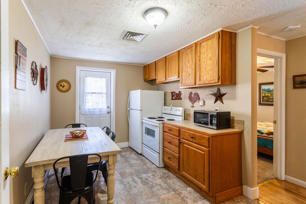 Your fully equipped kitchenette awaits with warm wood cabinets, modern appliances, and charming country touches—perfect for preparing home-cooked meals.