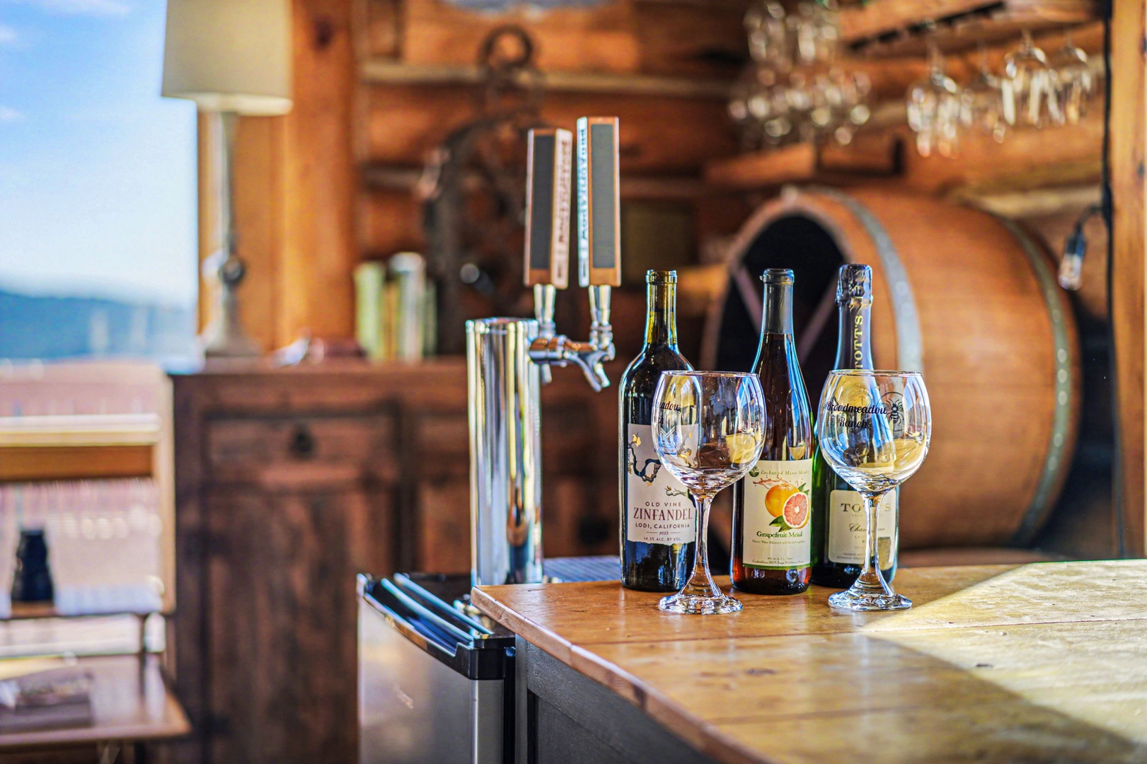 Savor fine wines in your rustic kitchen bar area, complete with elegant glassware and a charming wine barrel backdrop.
