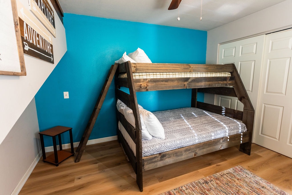 You'll love the rustic charm of this bunk bed setup, perfect for families with its spacious lower bunk and cozy upper retreat.