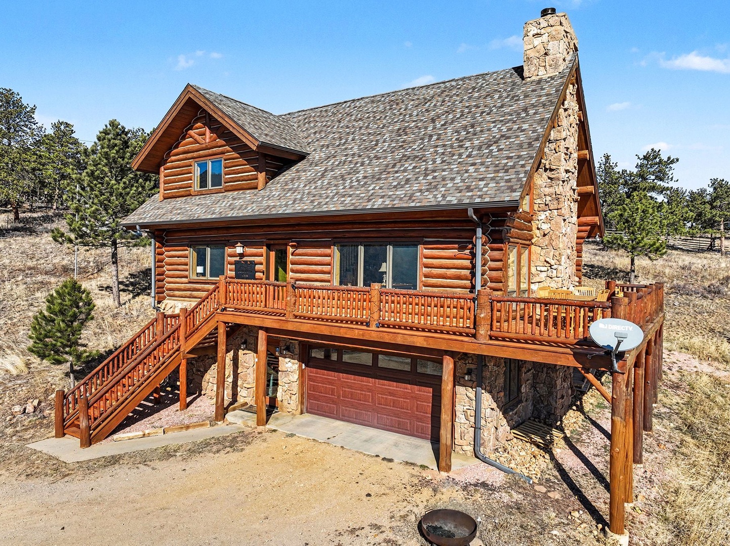 Rustic log cabin with stone chimney set among pine trees, featuring wraparound deck and mountain setting for peaceful getaway.