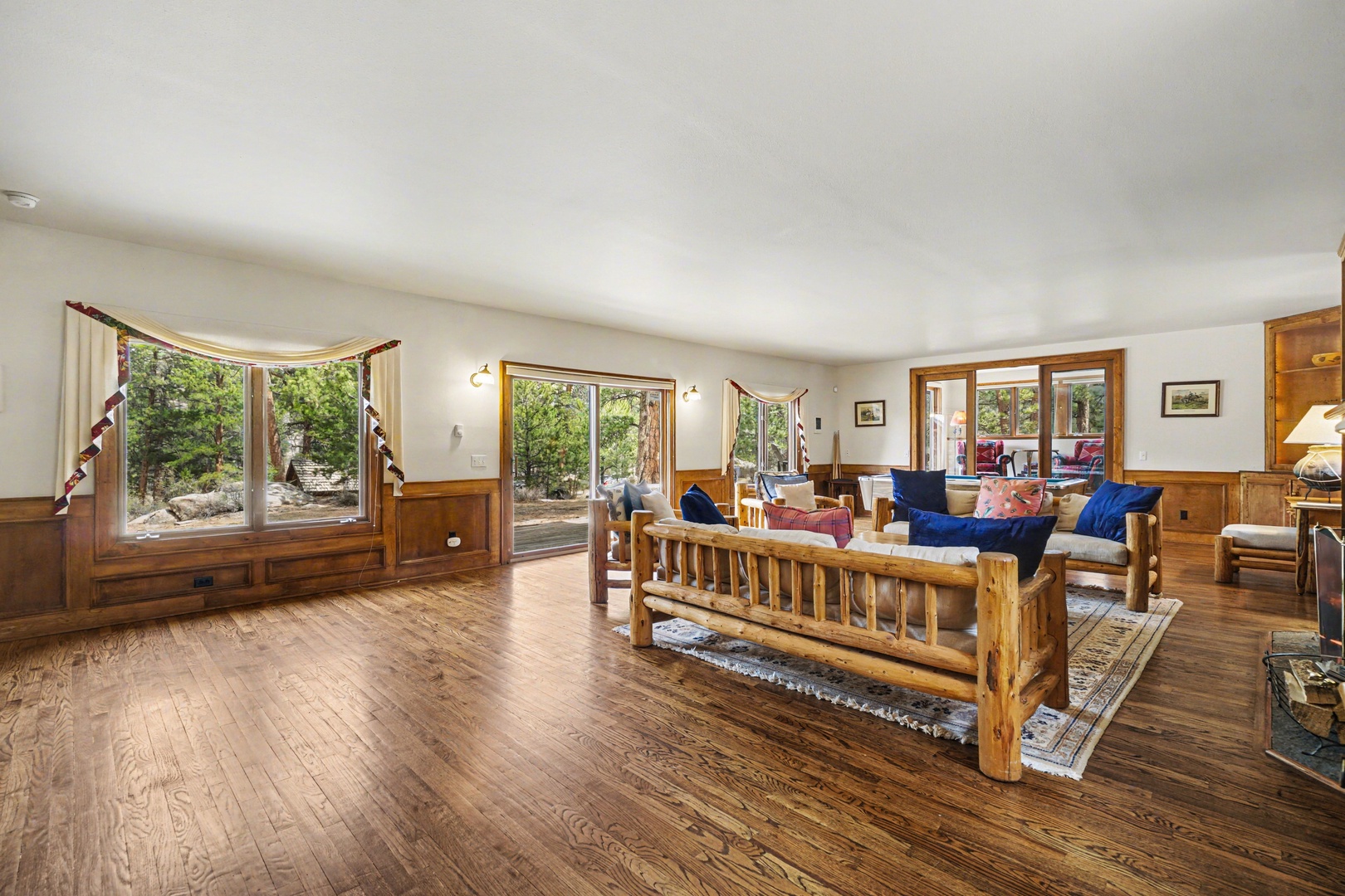 Unwind in your spacious living room where rustic log furniture meets comfort. Natural light streams through large windows revealing peaceful mountain views.