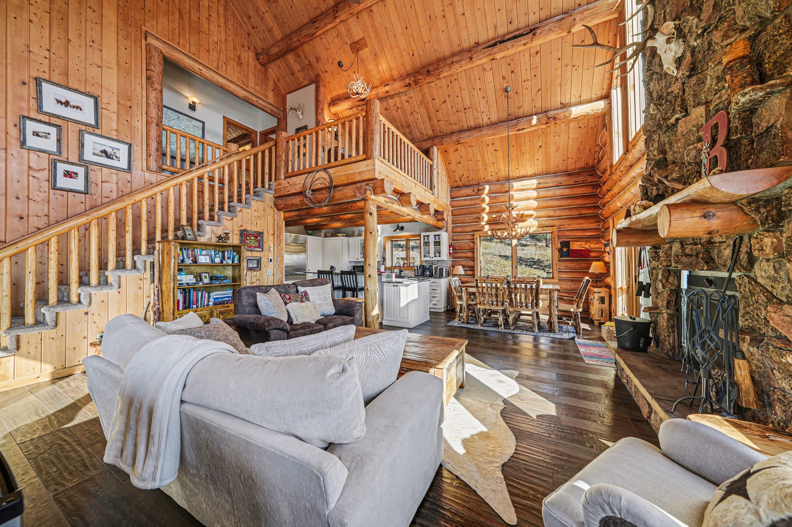 Relax in your spacious log cabin with soaring ceilings, stone fireplace, and cozy seating where rustic charm meets modern comfort.