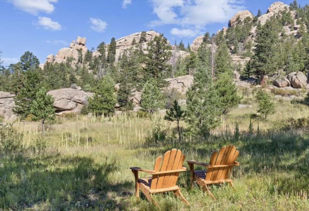 Settle into these cozy Adirondack chairs and soak in breathtaking mountain vistas framed by towering rock formations and pine forests.