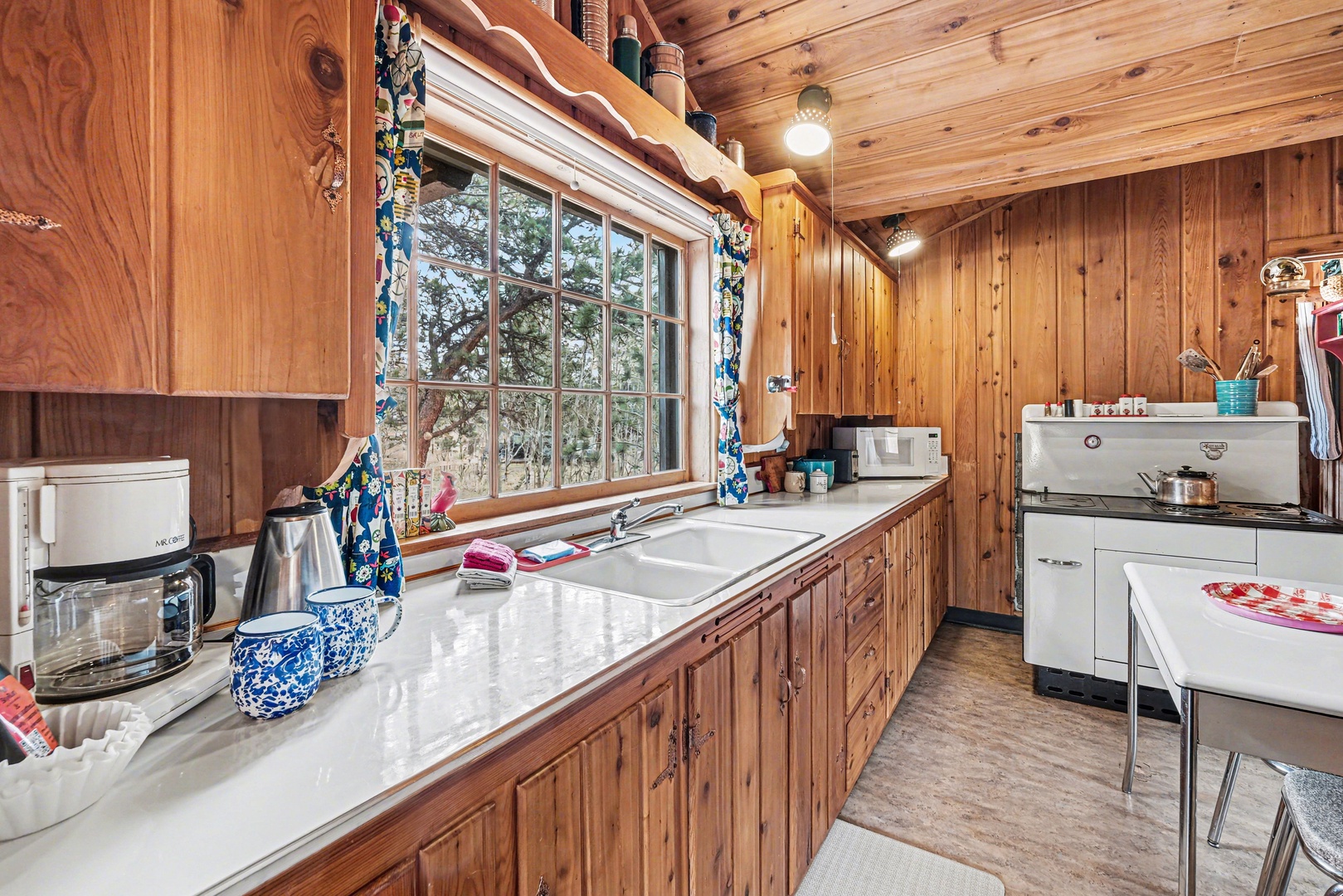 Step into this charming rustic kitchen with antique stove. Prepare meals with mountain and forest views through the window.