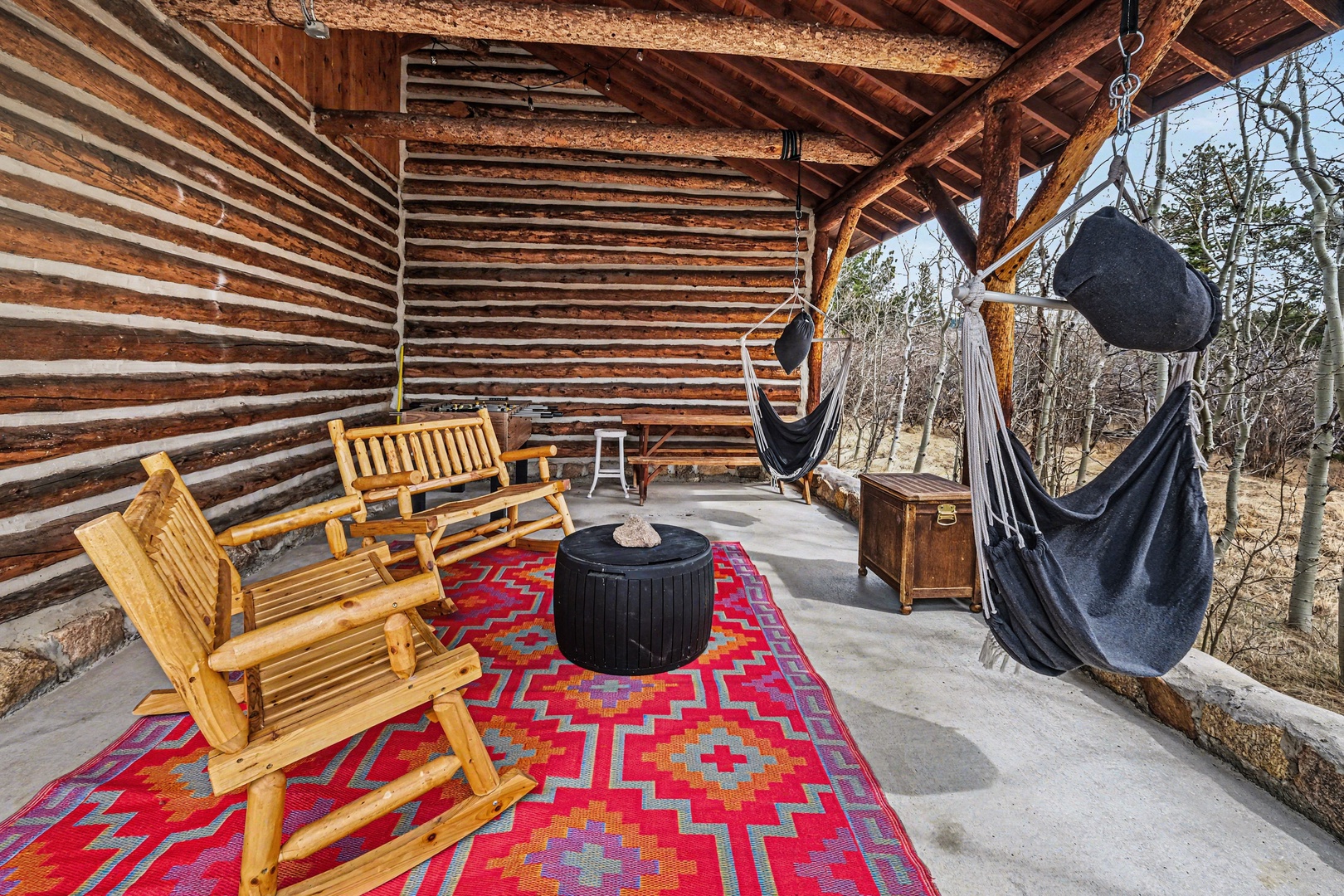 Unwind in your private covered patio with rustic wooden seating and a cozy hammock, gas grill and foosball table overlooking your own Aspen Grove.