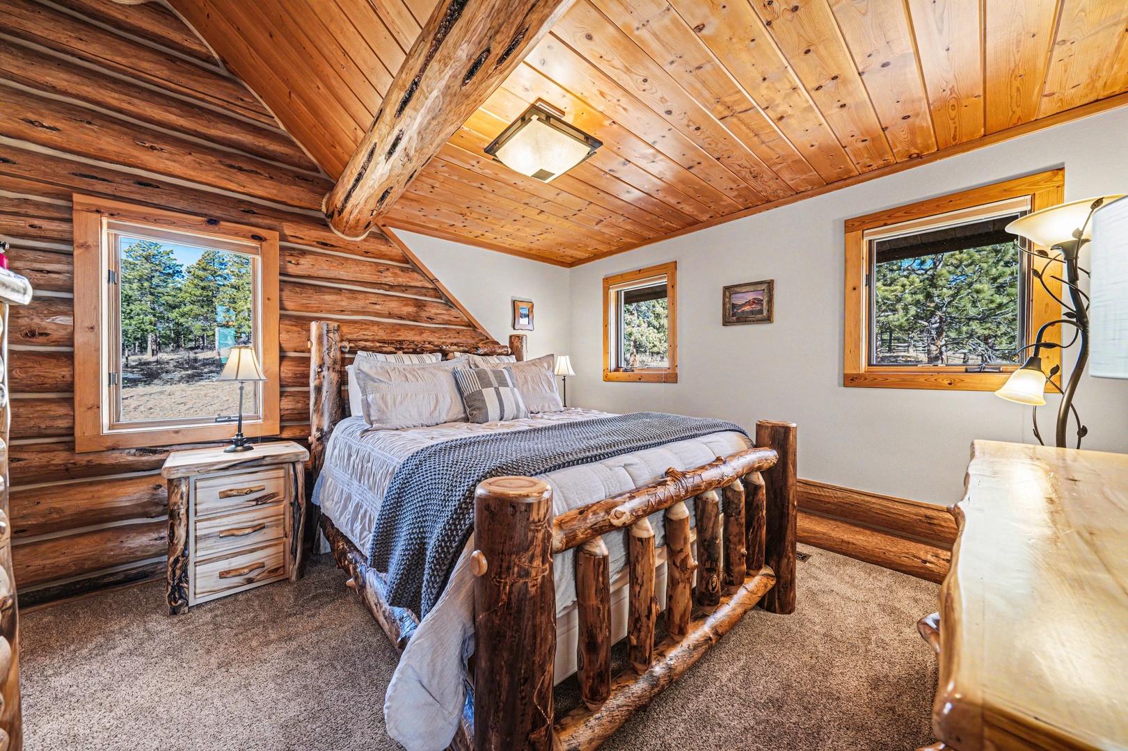 Drift off to dreamland in your cozy log bedroom, where rustic timber beams and forest views create the perfect mountain retreat sanctuary.