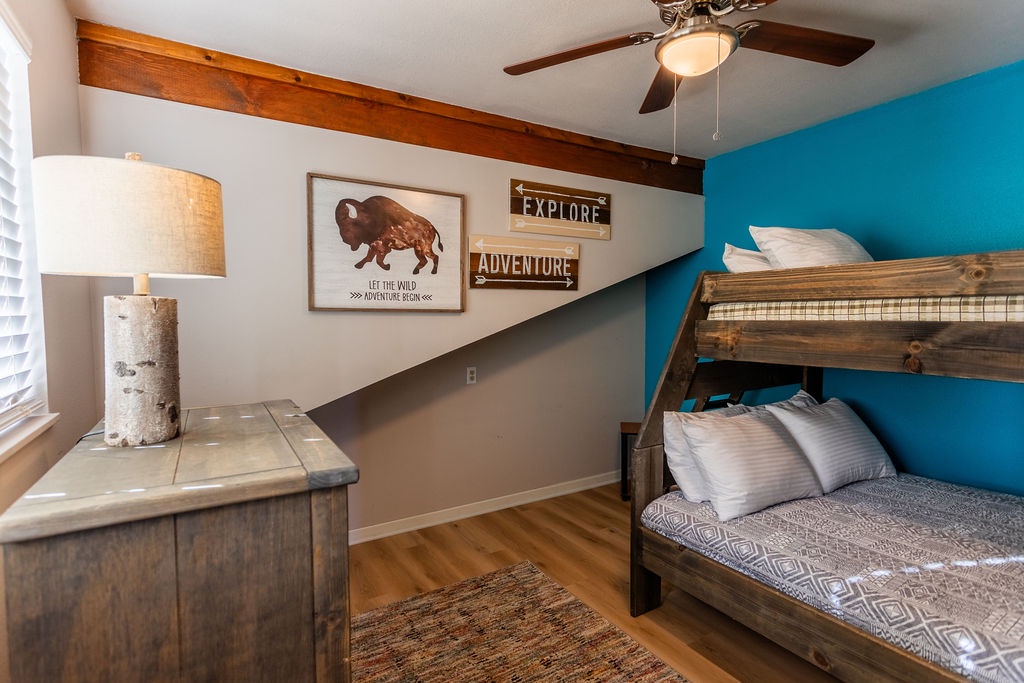 Your kids will love this adventure-themed bunk room with rustic wood beds and inspiring 'Explore' artwork to fuel their dreams.
