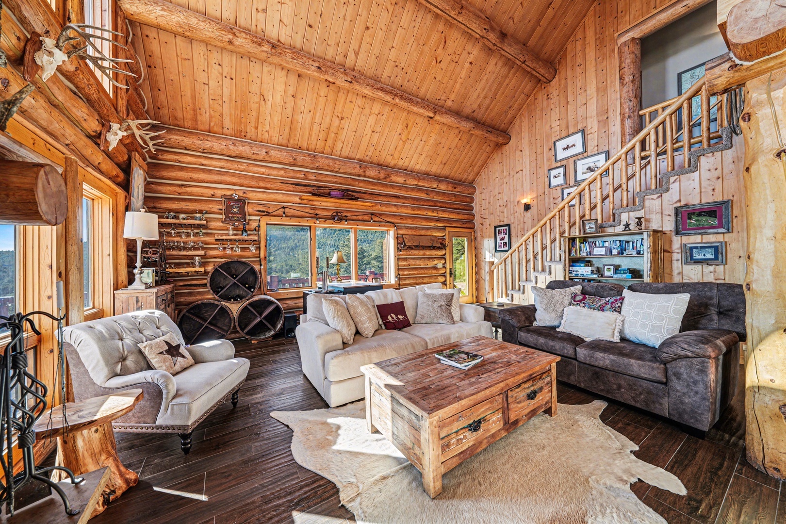 Sink into plush sofas surrounded by warm wood walls and rustic charm in this cozy mountain retreat living room.