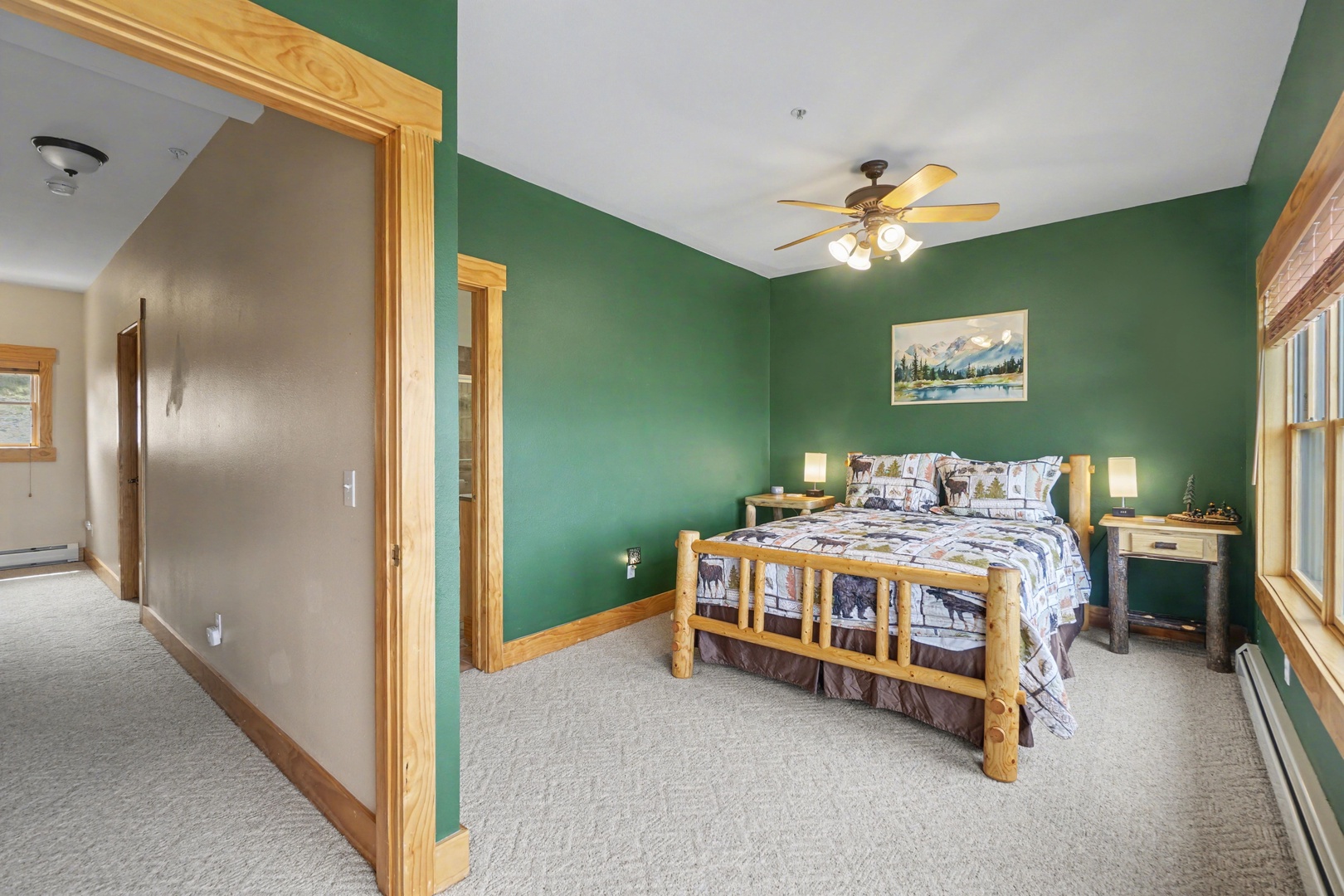 Rest peacefully in your cozy bedroom featuring rustic log furniture and soothing green walls that create the perfect mountain retreat atmosphere.