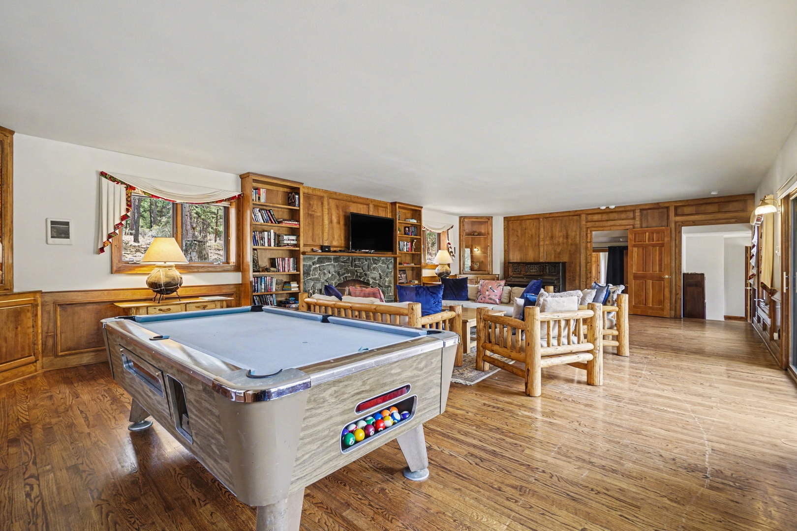 Unwind in your spacious game room with pool table, cozy seating, and rustic wood details for perfect evening entertainment.