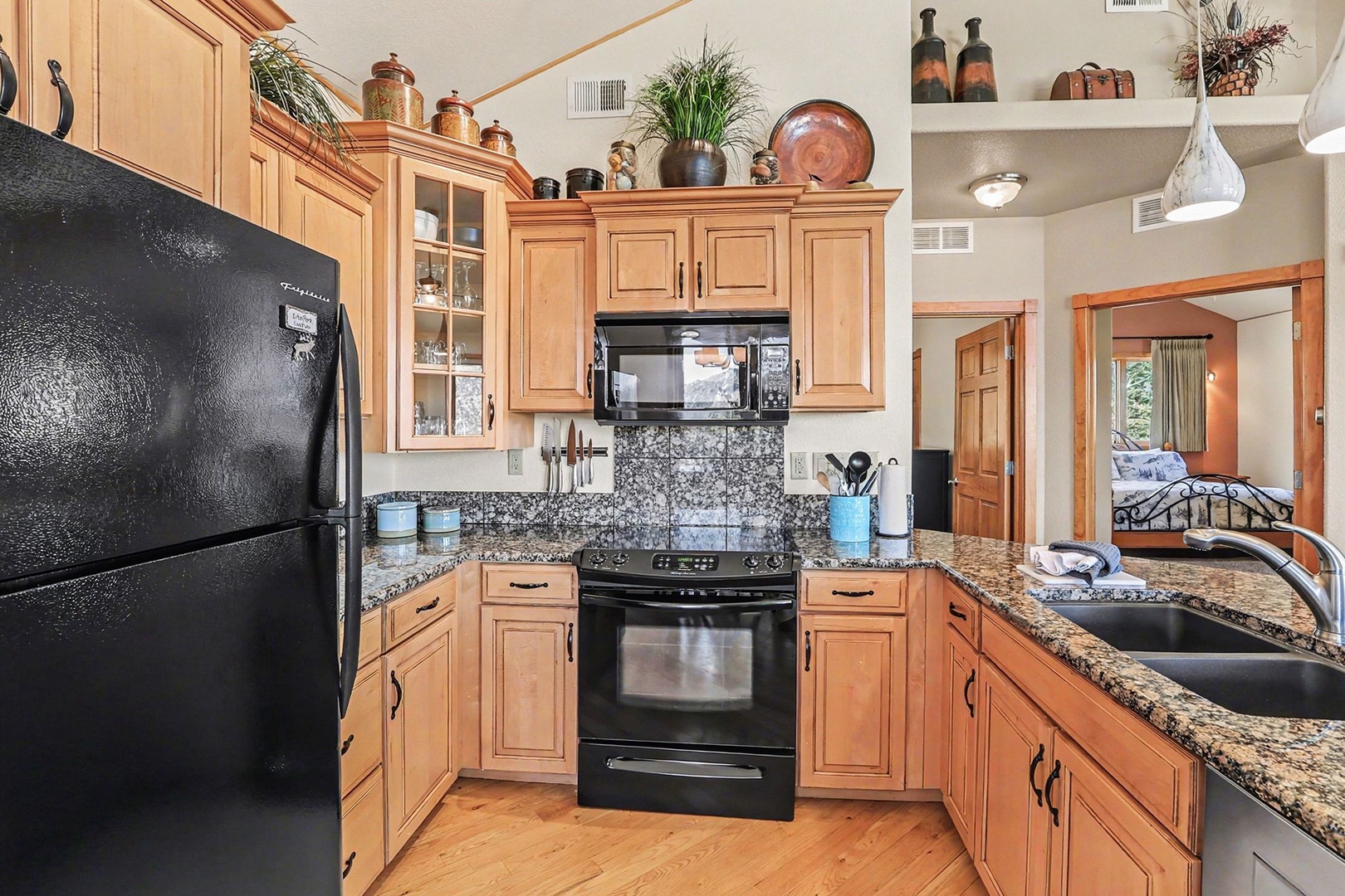 You'll love cooking in this fully equipped kitchen with granite counters, modern appliances, and warm wood cabinets perfect for preparing your favorite meals.