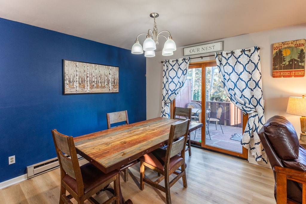 Gather around your dining table in this vibrant blue space, where meals become memories under the warm chandelier glow.