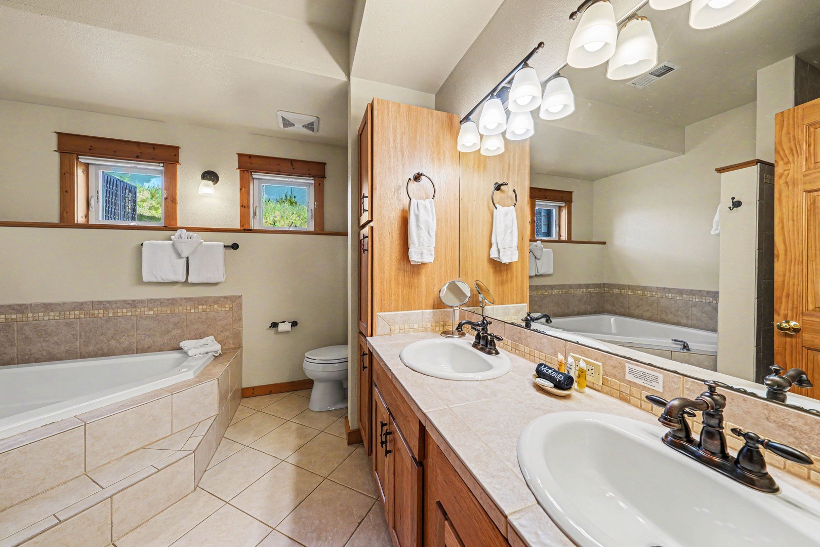 Step into your private spa-like retreat with dual vanities, a soaking tub, and warm natural light streaming through the windows—perfect for unwinding after a day of adventure.