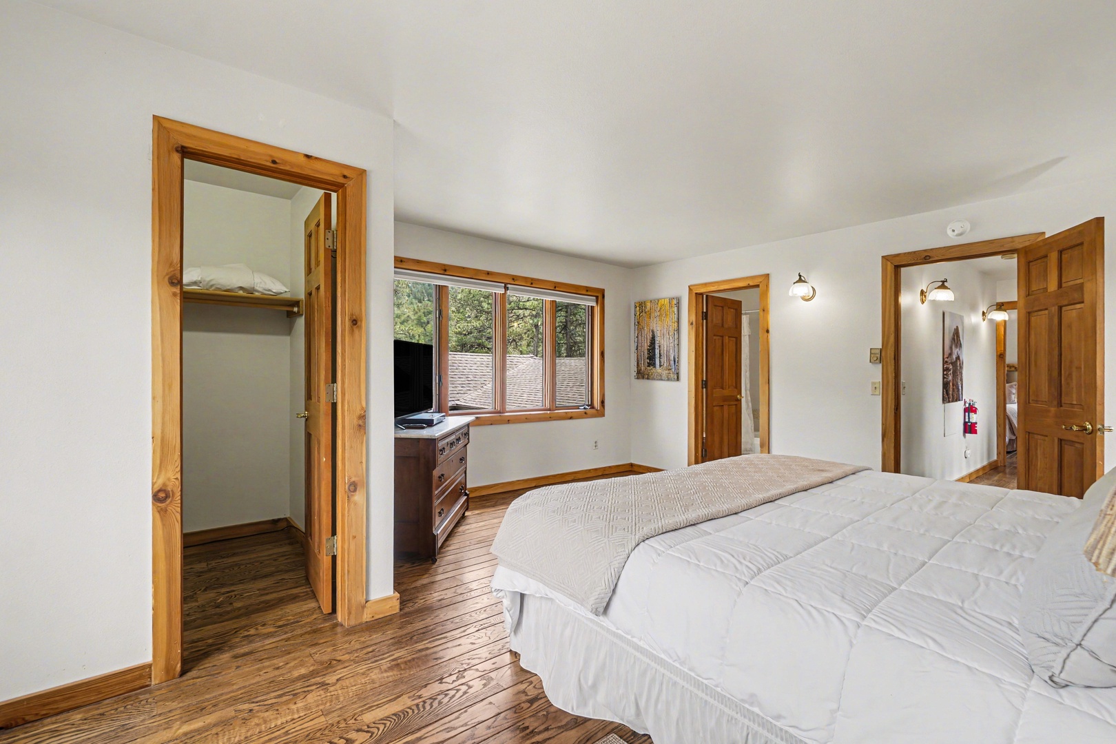 Rest peacefully in your spacious bedroom featuring warm wood accents, natural light, and an ensuite closet for your comfort.