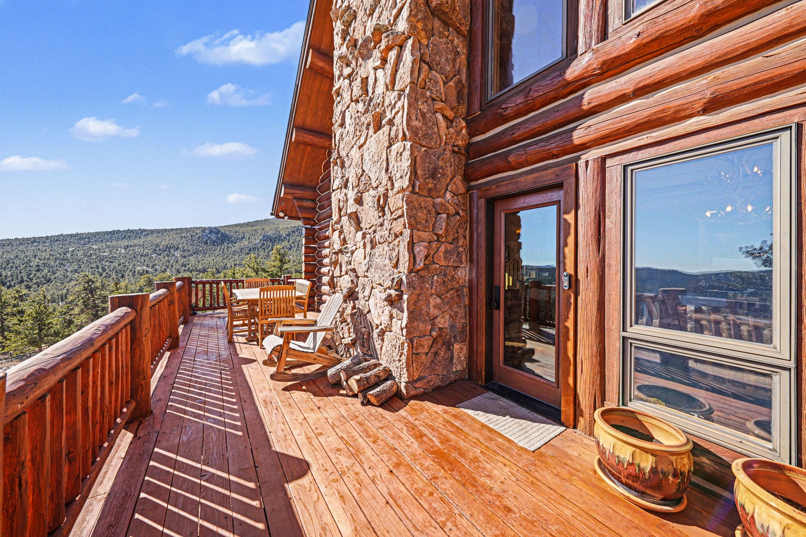 Rustic stone and timber lodge exterior with mountain forest views and outdoor seating.